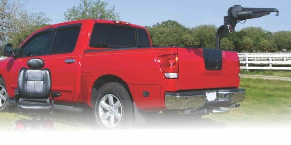 Image of red pickup truck with Harmar AL435T installed in rear bed of truck sitting in a field