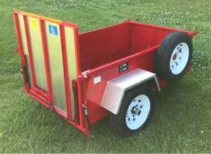 Red scootatrailer with no topper sitting on green grass