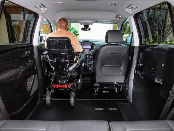 Man in power wheelchair sitting in drivers position of chevy traverse wheelchair accessible SUV