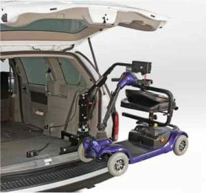 Minivan with Bruno Lifter hoist-style scooter lift coming out of rear hatch holding a blue mobility scooter