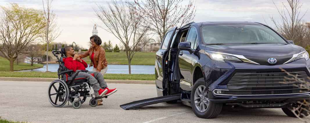 Lady with son in wheelchair at park outside Toyota sienna hybrid wheelchair van