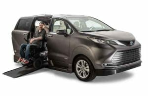 VMI Toyota Sienna Hybrid handicap van with guy in wheelchair coming down ramp