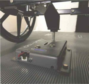 Image of a Qstraint QLK100 wheelchair securement docking station attached to a floor of a vehicle