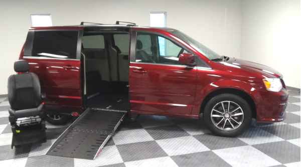 red dodge caravan wheelchair van from Adaptive Vans with ramp out and passenger seat sitting next to ramp