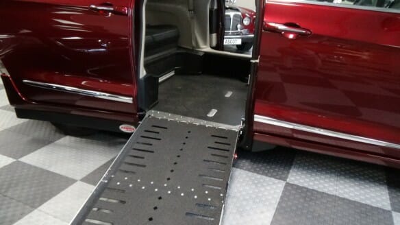 Close up image of wheelchair ramp on a red Chrysler Pacifica wheelchair van from Adaptive Vans.